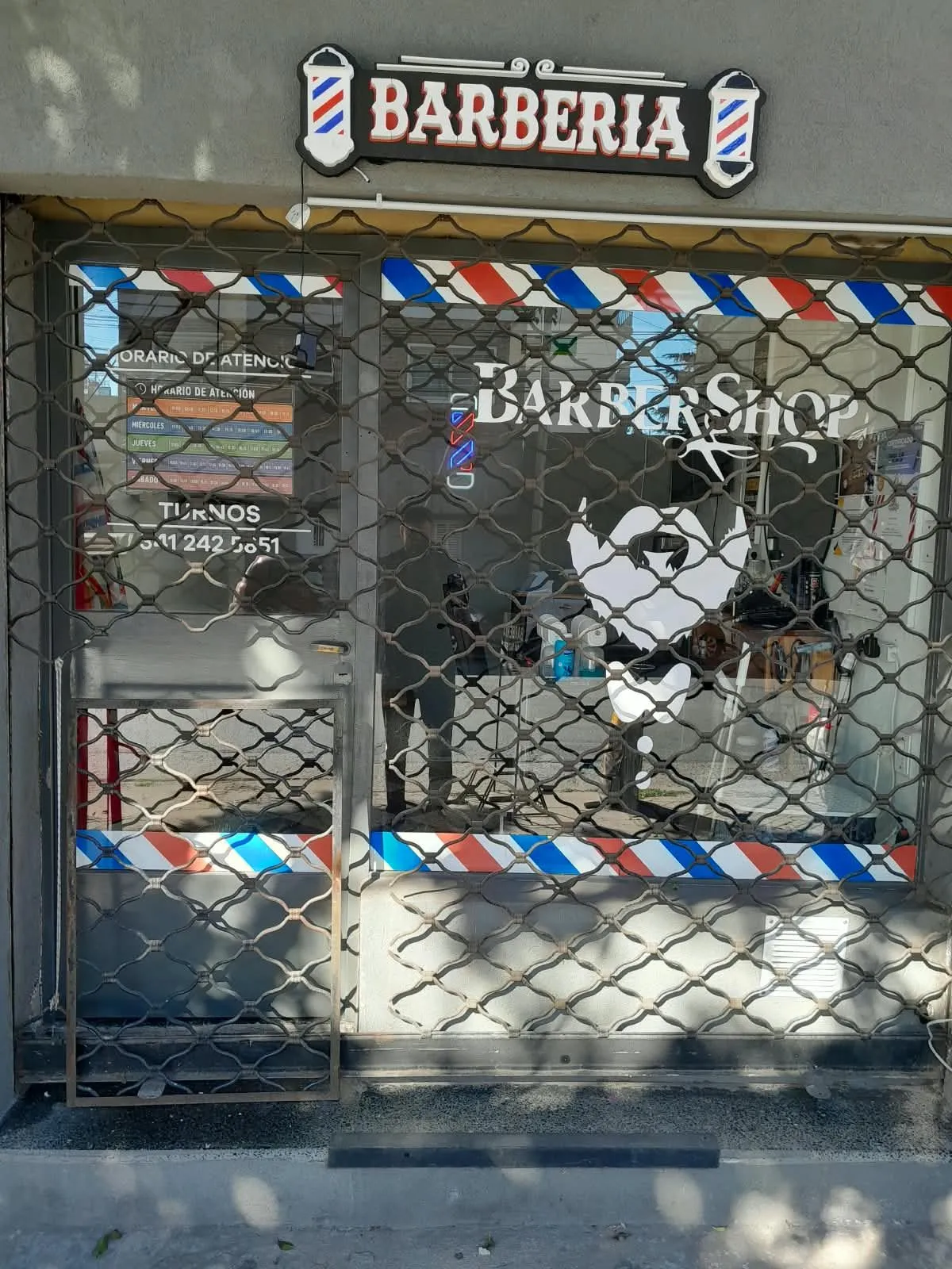 Cortina de malla de una barbería en Rosario